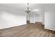 Open living room with elegant chandeliers, neutral walls, and wood-look floors, ready for personalization and comfort at 6793 W Angela Dr, Glendale, AZ 85308