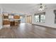 Spacious living room with light wood floors, large windows, and connected kitchen at 6793 W Angela Dr, Glendale, AZ 85308