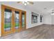 Spacious living room with wood floors, white walls, backyard facing doors, and large windows at 6793 W Angela Dr, Glendale, AZ 85308
