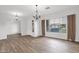 Bright living room with elegant chandeliers, large windows, neutral walls, and wood-look floors, ready for personalization and comfort at 6793 W Angela Dr, Glendale, AZ 85308