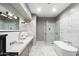 Elegant bathroom boasts marble flooring, a glass-enclosed shower, and a luxurious soaking tub at 7046 N 59Th Pl, Paradise Valley, AZ 85253