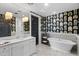 Stylish bathroom features a freestanding tub, unique wallpaper, and a spacious marble vanity at 7046 N 59Th Pl, Paradise Valley, AZ 85253