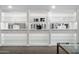 Bright custom closet features glass shelving, lighted displays, and white cabinets at 7046 N 59Th Pl, Paradise Valley, AZ 85253