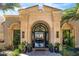 Grand entrance features a decorative iron door, stone columns, and lush plants, inviting guests into a luxurious home at 7046 N 59Th Pl, Paradise Valley, AZ 85253