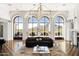 Bright living room with hardwood floors, soaring arched windows, elegant lighting, and mountain views at 7046 N 59Th Pl, Paradise Valley, AZ 85253