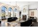 Bright living room with hardwood floors, a fireplace, arched windows, and comfortable seating areas and lovely mountain views at 7046 N 59Th Pl, Paradise Valley, AZ 85253