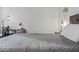 Bedroom view of a queen sized bed, a desk with lighting, bedside table, bike ornament, and white walls at 7625 E Camelback Rd # A114, Scottsdale, AZ 85251