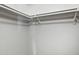 Empty walk-in closet with freshly painted white walls and white painted closet rods at 7625 E Camelback Rd # A114, Scottsdale, AZ 85251