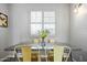 Modern dining room with metal table, yellow chairs, white window shutters and flower centerpiece at 7625 E Camelback Rd # A114, Scottsdale, AZ 85251