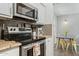Modern kitchen featuring stainless steel appliances, granite counters, and gray subway tile backsplash at 7625 E Camelback Rd # A114, Scottsdale, AZ 85251