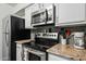 Modern kitchen with stainless steel appliances, including a microwave, oven, and refrigerator at 7625 E Camelback Rd # A114, Scottsdale, AZ 85251