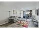 Bright living room featuring a gray sofa, colorful rug, and sliding glass doors to a patio at 7625 E Camelback Rd # A114, Scottsdale, AZ 85251