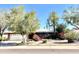 Charming single-story brick home featuring a lush front yard with mature trees and colorful flowering shrubs at 8552 E Vía Del Palacio --, Scottsdale, AZ 85258