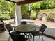 Covered patio with tiled floor, featuring a round table with four chairs, overlooking a landscaped backyard at 8552 E Vía Del Palacio --, Scottsdale, AZ 85258