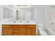 Bathroom with double sinks, wood cabinets, and a large mirror at 8817 S 13Th Way, Phoenix, AZ 85042