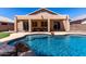 Back of the home with a covered patio, pool with a rock waterfall feature at 9511 E Kiva Ave, Mesa, AZ 85209