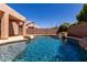 Backyard with swimming pool and rock waterfall feature under a clear blue sky at 9511 E Kiva Ave, Mesa, AZ 85209