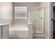 Bathroom featuring a tub, glass block window, and glass shower at 9511 E Kiva Ave, Mesa, AZ 85209