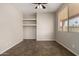Bright bedroom with window, ceiling fan, brown tile flooring and built-in shelving at 9511 E Kiva Ave, Mesa, AZ 85209