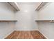 A spacious walk-in closet with hardwood floors and built-in shelving and racks at 9511 E Kiva Ave, Mesa, AZ 85209