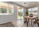 Bright dining room with a wooden table and chairs, large windows, and sliding glass door to the backyard at 9511 E Kiva Ave, Mesa, AZ 85209