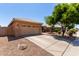 Single-story home with a two-car garage, xeriscaped yard, and a long driveway under a clear blue sky at 9511 E Kiva Ave, Mesa, AZ 85209