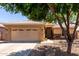 Charming single-story home featuring a two-car garage and xeriscaped front yard shaded by mature trees at 9511 E Kiva Ave, Mesa, AZ 85209