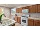 View of kitchen including oak cabinetry, tile countertops, and gas range at 9511 E Kiva Ave, Mesa, AZ 85209