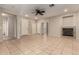 Open living room featuring a ceiling fan, fireplace, and neutral tile flooring at 9511 E Kiva Ave, Mesa, AZ 85209