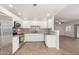 Open concept kitchen featuring stainless steel appliances, neutral granite countertops, tile floors, and seamless flow into the living area at 9555 E Raintree Dr # 1018, Scottsdale, AZ 85260