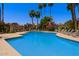 Community pool area with lounge chairs, palm trees and desert landscaping under a bright blue sky at 10017 E Mountain View Rd # 1087, Scottsdale, AZ 85258