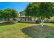A backyard view features large shade trees and an enclosed patio at 11012 W Caron Dr, Sun City, AZ 85351