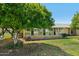 The exterior features an enclosed back porch and lush green landscaping at 11012 W Caron Dr, Sun City, AZ 85351