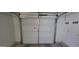 Clean garage with a new white door, overhead rack and white door to interior at 11012 W Caron Dr, Sun City, AZ 85351