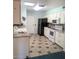 A charming kitchen is equipped with white cabinets, sleek appliances, and a tiled floor at 11012 W Caron Dr, Sun City, AZ 85351