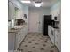 A well-lit kitchen is equipped with white cabinets, sleek appliances, and a tiled floor at 11012 W Caron Dr, Sun City, AZ 85351