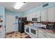 Functional kitchen featuring white cabinets, black refrigerator, and tile flooring at 11012 W Caron Dr, Sun City, AZ 85351