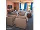 A virtually staged living room features ample seating, a large TV, and bright curtains at 11012 W Caron Dr, Sun City, AZ 85351