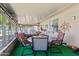 Enclosed sunroom with an outdoor dining set and large windows for natural light and outdoor views at 11012 W Caron Dr, Sun City, AZ 85351