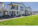 Wide exterior showcasing a modern townhome with an inviting entrance, and green lawn at 11300 N Casa Dega N Dr # 1047, Surprise, AZ 85388