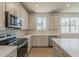 Modern kitchen with stainless steel appliances, quartz countertops, and white cabinetry at 11300 N Casa Dega N Dr # 1047, Surprise, AZ 85388