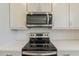 Close-up showcasing new stainless steel appliances and white cabinets in a modern kitchen at 11300 N Casa Dega N Dr # 1047, Surprise, AZ 85388