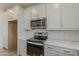 Bright kitchen features stainless steel appliances, white cabinets, and light countertops at 11300 N Casa Dega N Dr # 1047, Surprise, AZ 85388