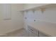 Bright laundry room offers upper shelf storage and sleek gray cabinetry with counterspace at 11300 N Casa Dega N Dr # 1047, Surprise, AZ 85388