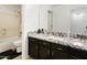 Bathroom showcasing a black vanity with granite countertop and a shower-tub combination at 11959 W Vernon Ave, Avondale, AZ 85392