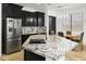 Modern kitchen with granite countertops, stainless steel appliances, and black cabinetry at 11959 W Vernon Ave, Avondale, AZ 85392