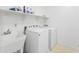 Practical laundry room with a utility sink, washer, dryer, and shelving at 11959 W Vernon Ave, Avondale, AZ 85392