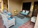 Relaxing covered patio with wicker furniture set upon a decorative area rug at 14300 W Bell Rd # 58, Surprise, AZ 85374
