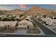 A birds eye view of a desert community at sunset featuring neutral colored homes with tile roofs and majestic mountain views at 14823 S 13Th Pl, Phoenix, AZ 85048