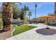 Expansive backyard with artificial turf, patio area, and mature landscaping creates a welcoming outdoor space at 14823 S 13Th Pl, Phoenix, AZ 85048